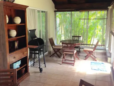 a living room with a table and chairs and a window at Villas Del Jardin 7 in Juan Dolio