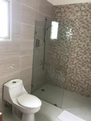 a bathroom with a toilet and a glass shower at Centro de Santiago in Santiago de los Caballeros