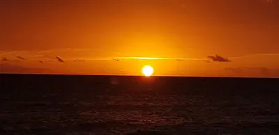 a sunset over the ocean with the sun setting at Appartamento Vista Mare in Bayahibe