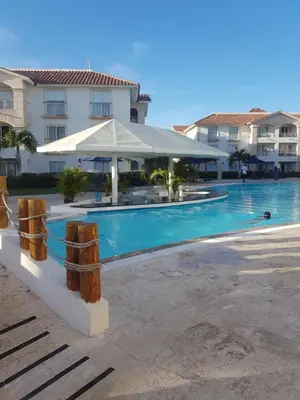 a swimming pool with an umbrella next to a building at Appartamento Vista Mare in Bayahibe