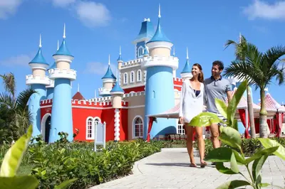 a man and a woman standing in front of a castle at Bahia Principe Fantasia Punta Cana - All Inclusive in Punta Cana