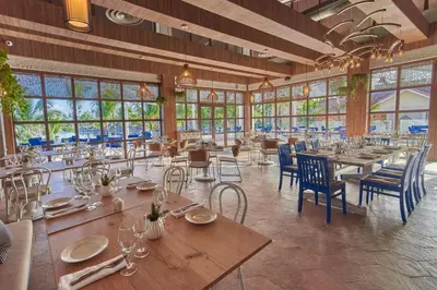 a dining room with tables and chairs and windows at Bahia Principe Grand Aquamarine - Adults Only All Inclusive in Punta Cana