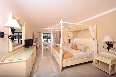 a bedroom with a white canopy bed and a desk at Bahia Principe Grand Aquamarine - Adults Only All Inclusive in Punta Cana