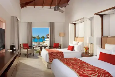 a hotel room with two beds and a balcony at Dreams Dominicus La Romana Resort & Spa in Bayahibe