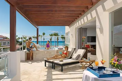 a woman sitting on a patio in a villa at Dreams Dominicus La Romana Resort & Spa in Bayahibe