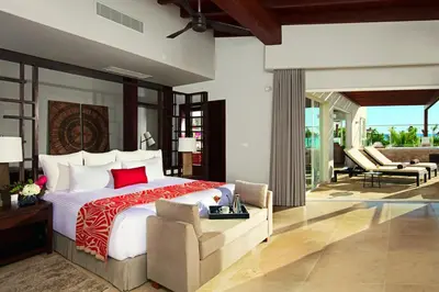 a bedroom with a large bed and a chair at Dreams Dominicus La Romana Resort & Spa in Bayahibe