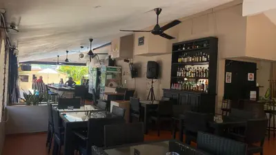 a restaurant with tables and chairs and a bar at Hotel Don Andres in Sosúa