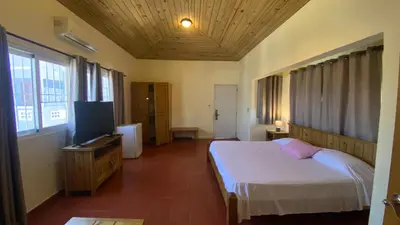 a bedroom with a bed and a flat screen tv at Hotel Don Andres in Sosúa