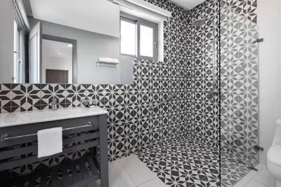 a bathroom with a black and white patterned wall at Gran Hotel Europa Santo Domingo Trademark Collection by Wyndham in Santo Domingo