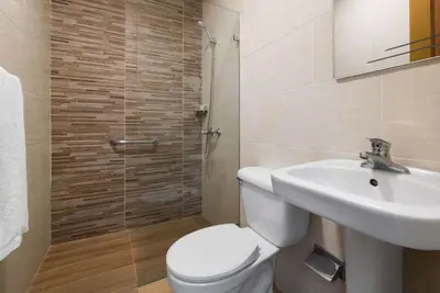 a bathroom with a white toilet and a sink at Gran Hotel Europa Santo Domingo Trademark Collection by Wyndham in Santo Domingo