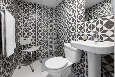 a black and white bathroom with a toilet and a sink at Gran Hotel Europa Santo Domingo Trademark Collection by Wyndham in Santo Domingo