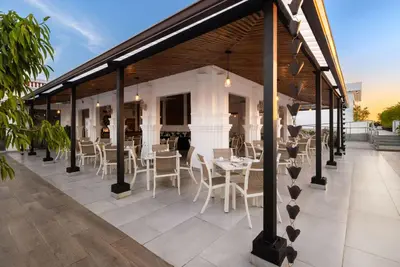 a restaurant with white chairs and tables on a patio at Gran Hotel Europa Santo Domingo Trademark Collection by Wyndham in Santo Domingo