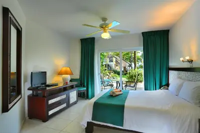 a bedroom with a bed and a television and a window at Hotel Villa Taina in Cabarete