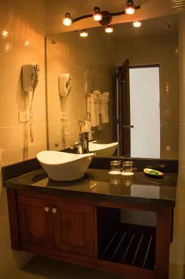 a bathroom with a sink and a large mirror at Hotel Villa Taina in Cabarete