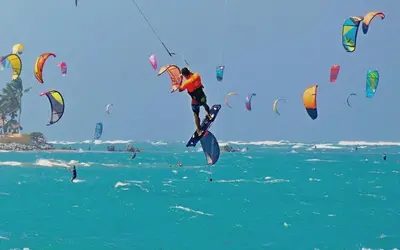 a group of people flying kites in the ocean at Hotel Villa Taina in Cabarete