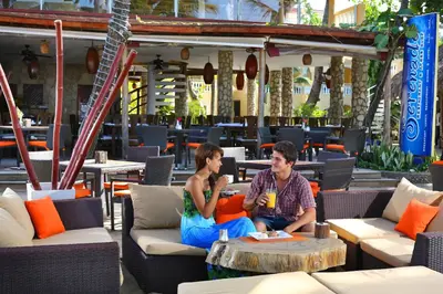 a man and woman sitting on chairs in a patio at Hotel Villa Taina in Cabarete