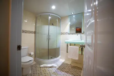 a bathroom with a shower and a toilet and a sink at Hotel Real Bella Vista in Santo Domingo
