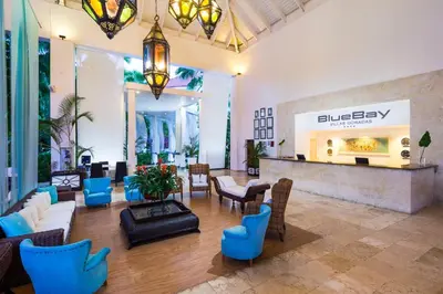 a lobby of a hotel with blue chairs and a fireplace at BlueBay Villas Doradas Adults Only-All Inclusive in San Felipe de Puerto Plata