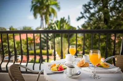 a table with two glasses of orange juice and fruit at BlueBay Villas Doradas Adults Only-All Inclusive in San Felipe de Puerto Plata