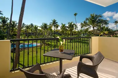 a balcony with a table and chairs and a pool at Ocean Blue & Sand Beach Resort - All Inclusive in Punta Cana