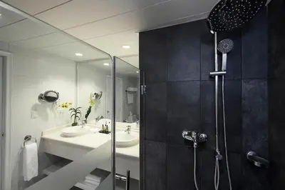 a bathroom with two sinks and a shower at Ocean Blue & Sand Beach Resort - All Inclusive in Punta Cana