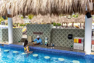 a man and a little girl in a swimming pool at Grand Sirenis Punta Cana Resort & Aquagames - All Inclusive in Punta Cana