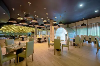 a dining room with tables and chairs and lights at Grand Sirenis Punta Cana Resort & Aquagames - All Inclusive in Punta Cana