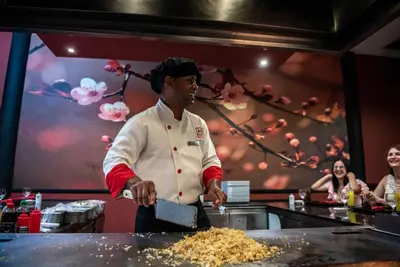 a chef standing in a kitchen preparing food at Grand Sirenis Punta Cana Resort & Aquagames - All Inclusive in Punta Cana