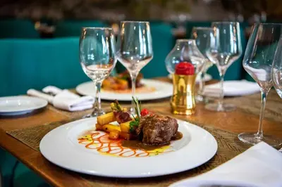 a plate of food on a table with wine glasses at Grand Sirenis Punta Cana Resort & Aquagames - All Inclusive in Punta Cana
