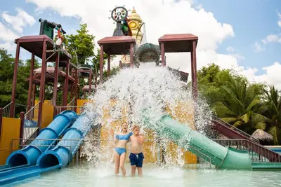 two children standing in front of a water slide at a water park at Grand Sirenis Punta Cana Resort & Aquagames - All Inclusive in Punta Cana