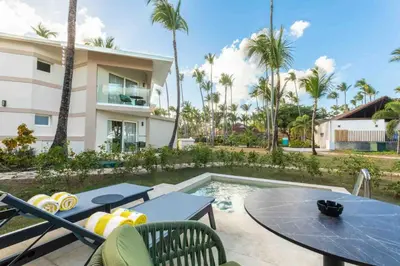 a patio with a table and chairs next to a pool at Grand Palladium Select Bávaro - All Inclusive in Punta Cana