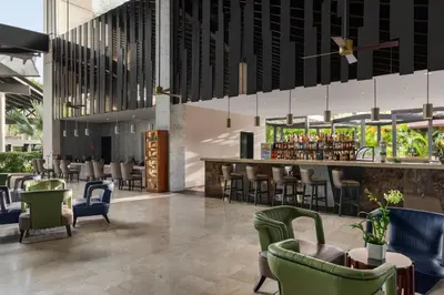 a restaurant with green chairs and a bar at Grand Palladium Punta Cana Resort & Spa - All Inclusive in Punta Cana