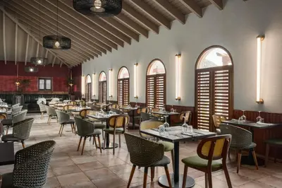 a restaurant with tables and chairs and windows at Grand Palladium Punta Cana Resort & Spa - All Inclusive in Punta Cana