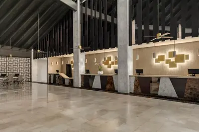 a large lobby with tables and chairs in a building at Grand Palladium Punta Cana Resort & Spa - All Inclusive in Punta Cana