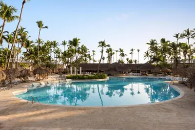 a swimming pool at a resort with palm trees at Grand Palladium Palace Resort Spa & Casino - All Inclusive in Punta Cana