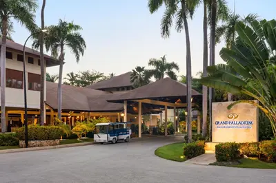 a bus parked in front of a building with palm trees at Grand Palladium Palace Resort Spa & Casino - All Inclusive in Punta Cana