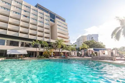 a large swimming pool in front of a building at Dominican Fiesta Hotel in Santo Domingo