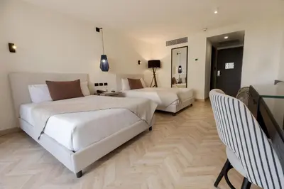 a hotel room with two beds and a couch at Dominican Fiesta Hotel in Santo Domingo