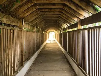 a long wooden tunnel with a light in the distance at Plaza Real Resort in Juan Dolio
