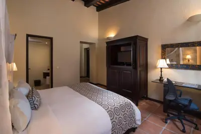a bedroom with a bed and a desk with a computer at Hodelpa Nicolás de Ovando in Santo Domingo