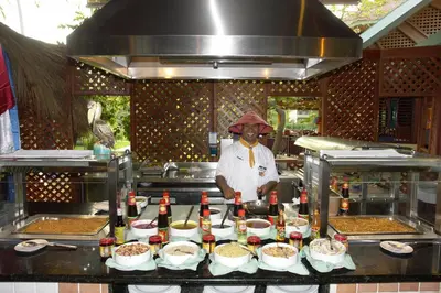 a chef standing in a kitchen with some food at VIK hotel Arena Blanca in Punta Cana