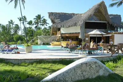 a group of people sitting in chairs by a swimming pool at VIK Hotel Cayena Beach All Inclusive in Punta Cana