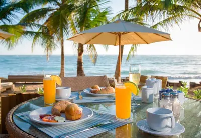 a table with food and orange juice on the beach at VIK Hotel Cayena Beach All Inclusive in Punta Cana