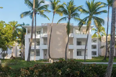 a building with palm trees in front of it at Grand Bavaro Princess - All Inclusive in Punta Cana