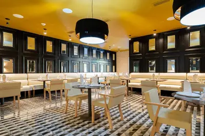 a restaurant with tables and chairs and a yellow ceiling at Punta Cana Princess Adults Only - All Inclusive in Punta Cana