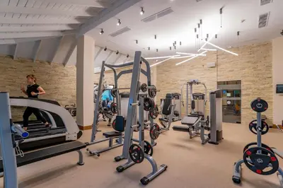 a gym with cardio equipment and a woman running on a treadmill at Caribe Deluxe Princess - All Inclusive in Punta Cana