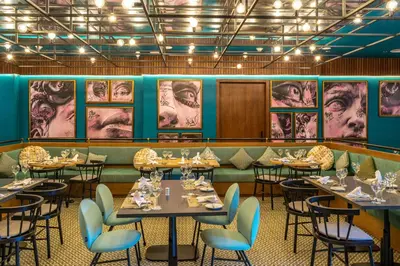 a dining room with tables and chairs and posters at Caribe Deluxe Princess - All Inclusive in Punta Cana