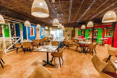 a restaurant with tables and chairs and colorful walls at Caribe Deluxe Princess - All Inclusive in Punta Cana