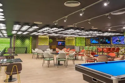a pool table in a restaurant with tables and chairs at Caribe Deluxe Princess - All Inclusive in Punta Cana