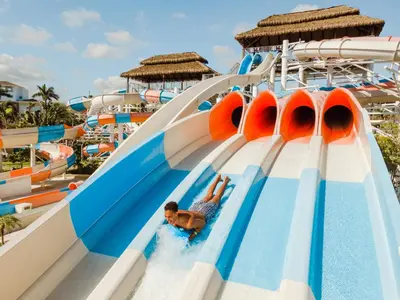 a boy sliding down a water slide at a water park at Hard Rock Hotel & Casino Punta Cana - All Inclusive in Punta Cana